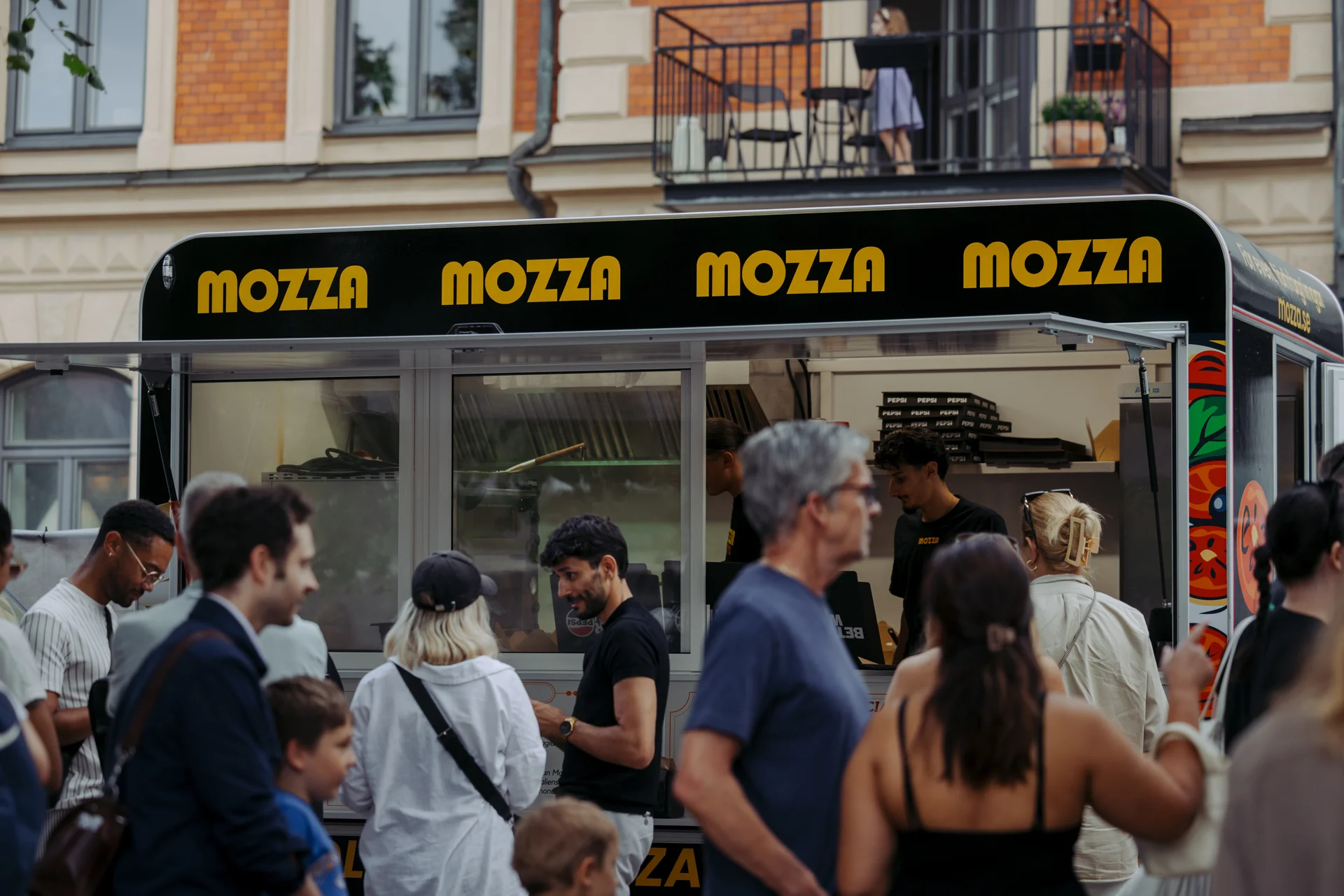 Gäster samlas framför Mozzas foodtruck på ett event